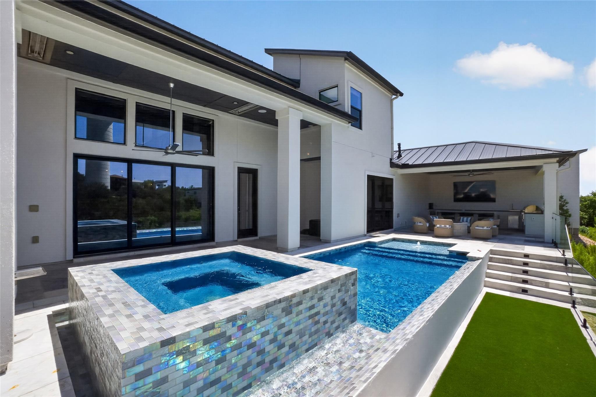 An inviting pool and spa area with a covered outd