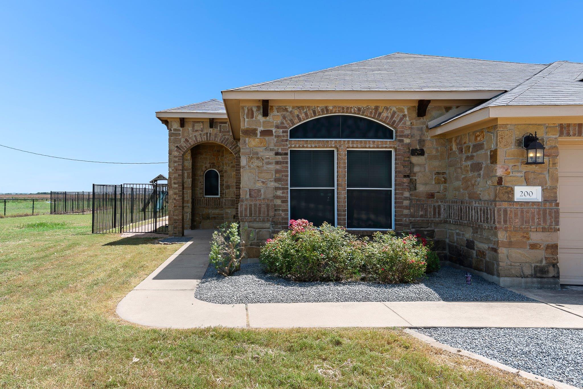 A welcoming stone facade with an arched entry inv