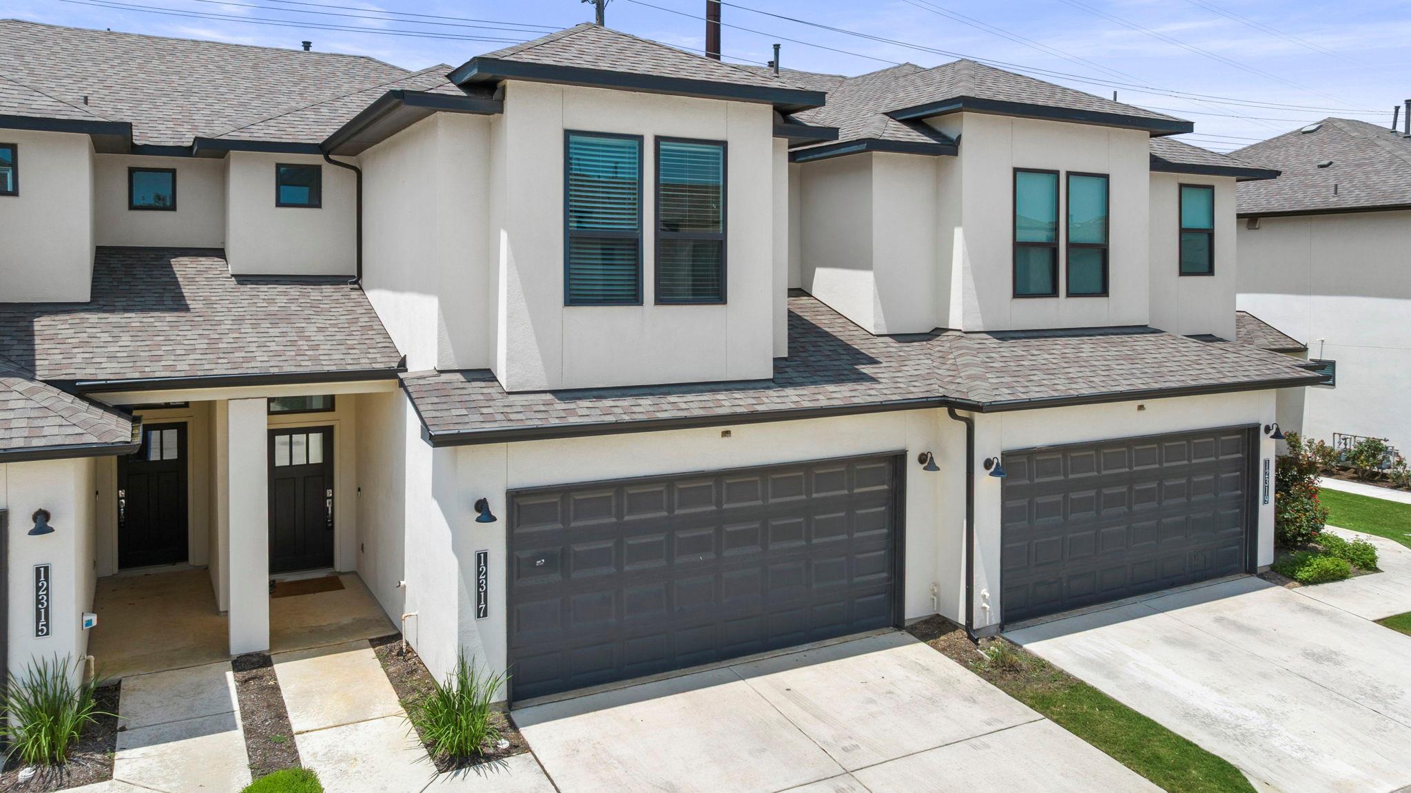 Modern townhome exterior featuring a white stucco