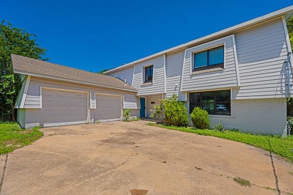 A classic facade with a spacious driveway leads t