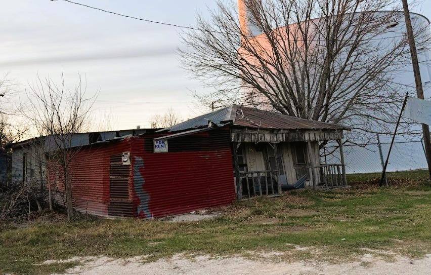 A rustic, weathered structure with a corrugated m