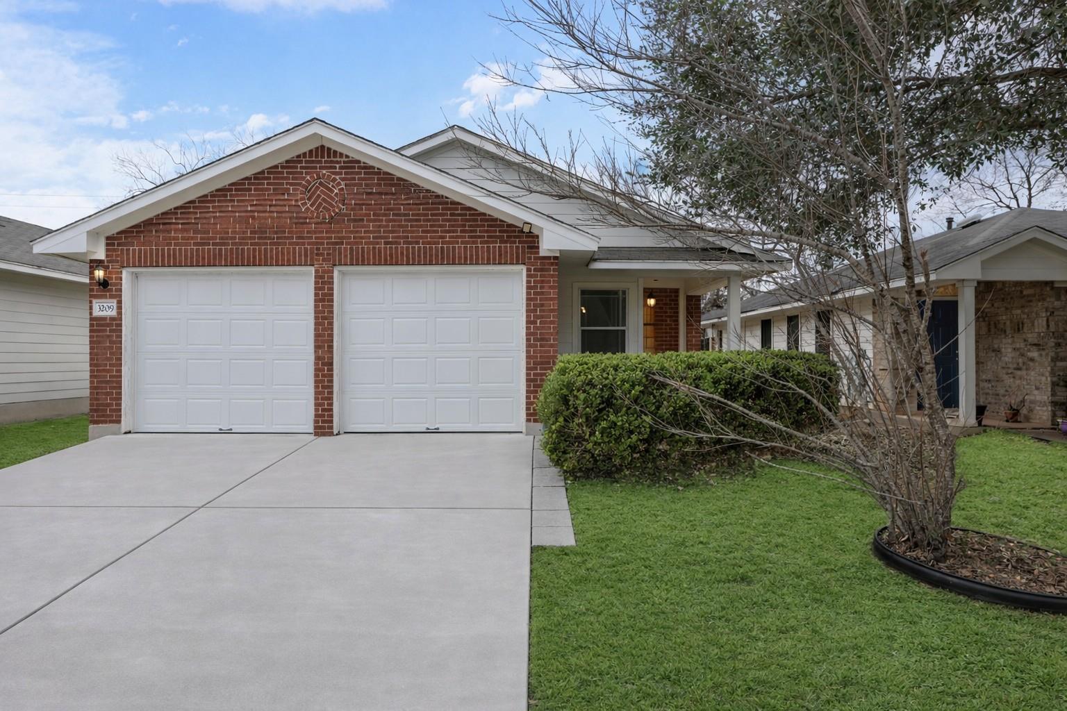 A classic brick facade welcomes with a double gar