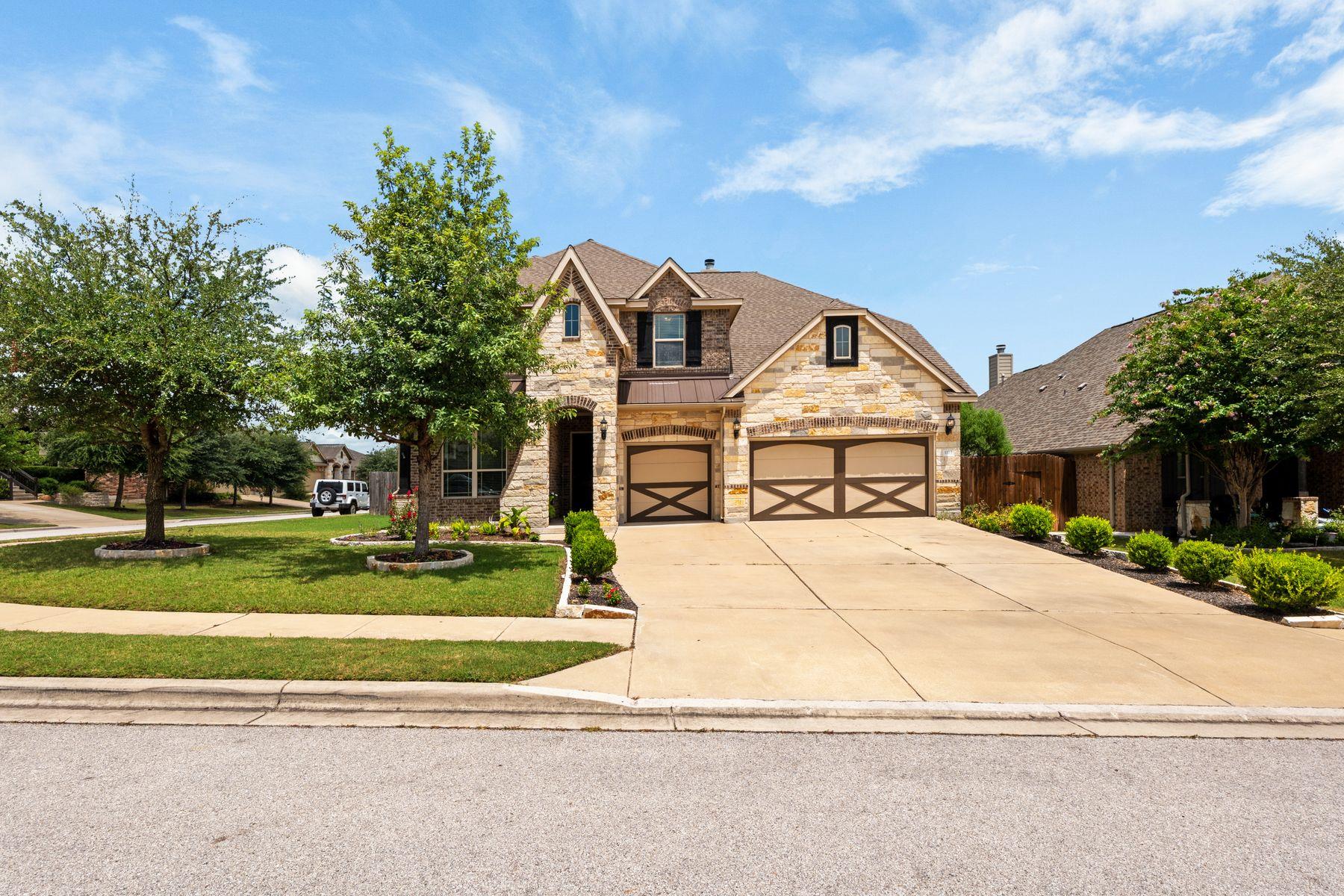 A stone and brick facade home with a spacious dri