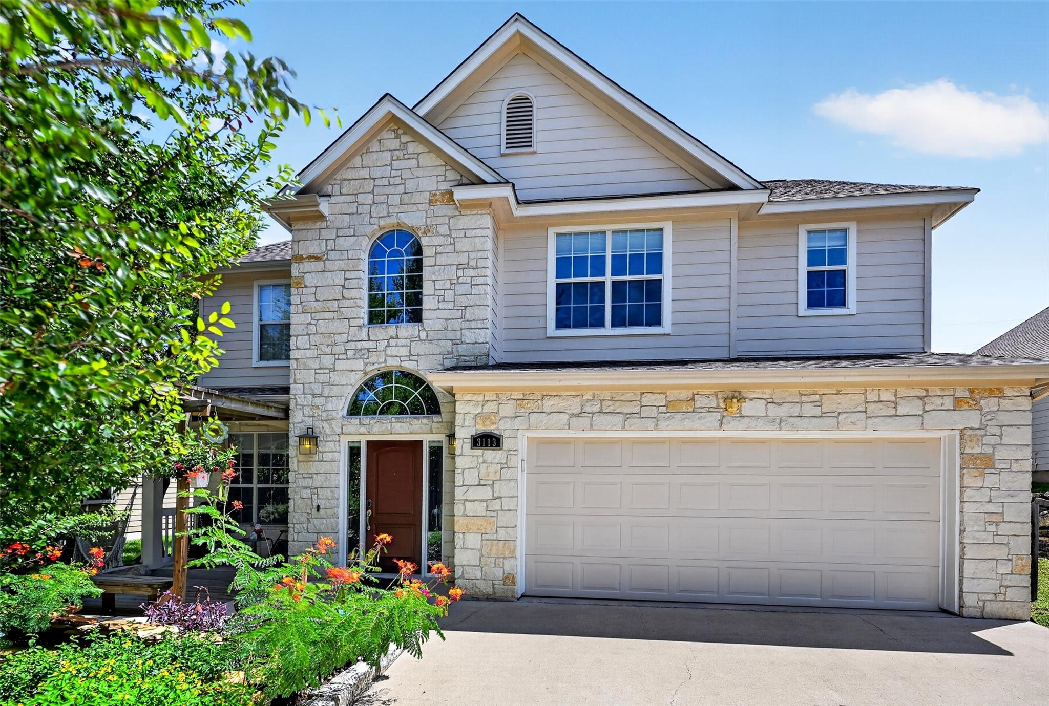 Stone and siding create an inviting facade, compl