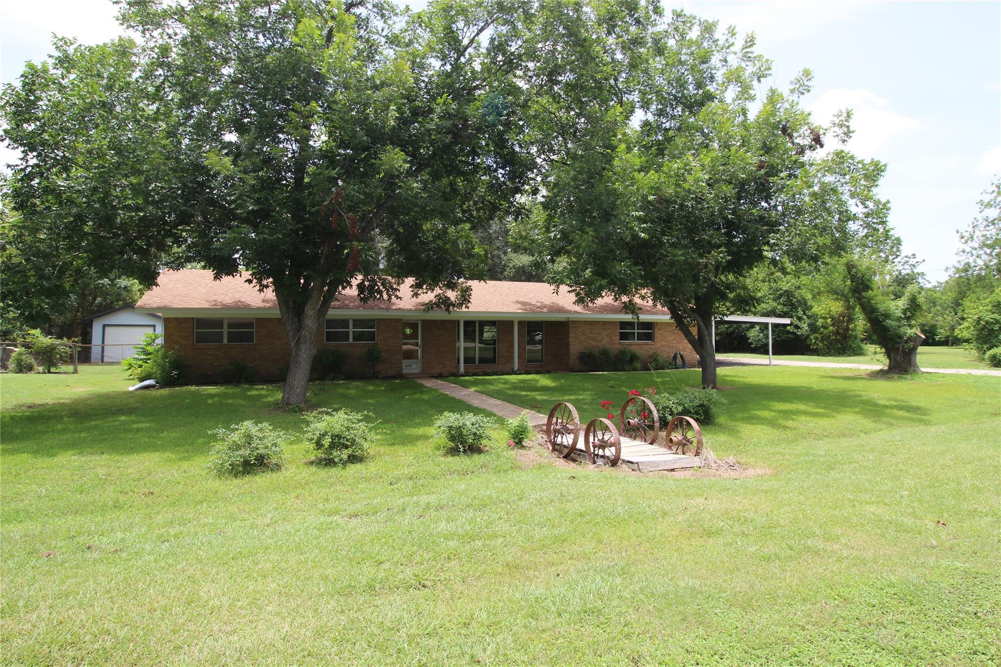 Mature trees shade this brick residence, offering