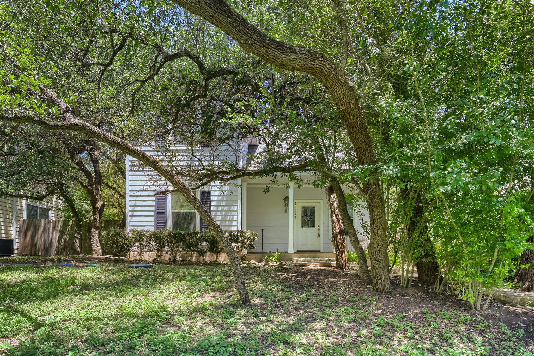 Mature trees shade the inviting front porch and a