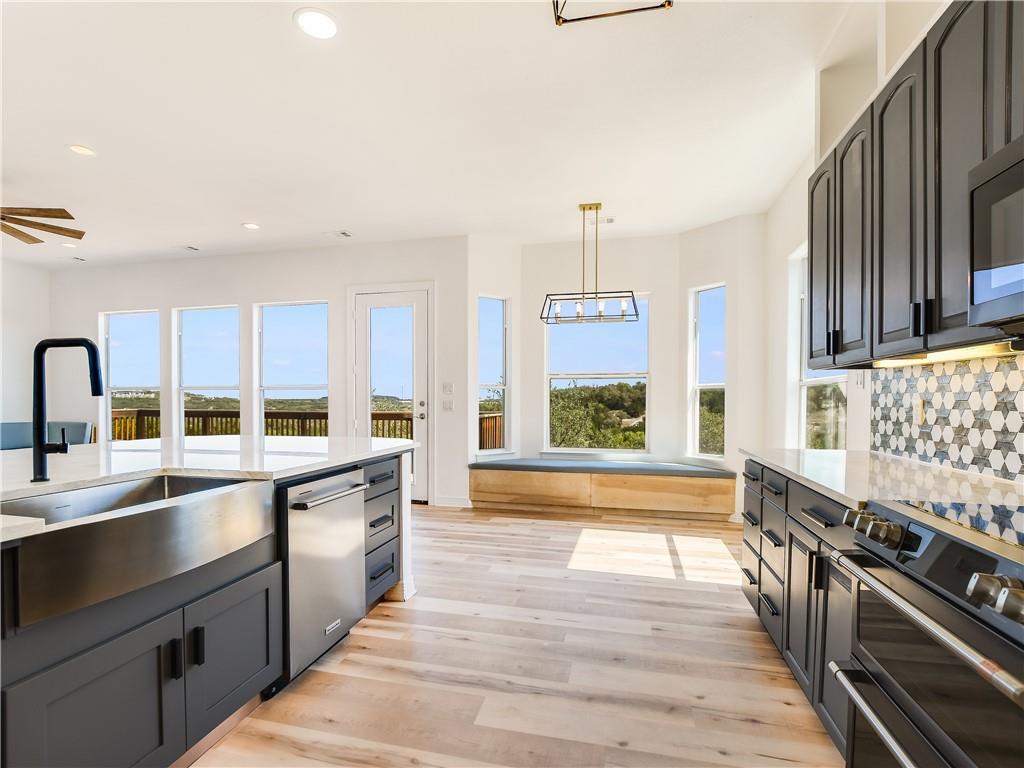 A well-lit kitchen boasts high ceilings and sweep