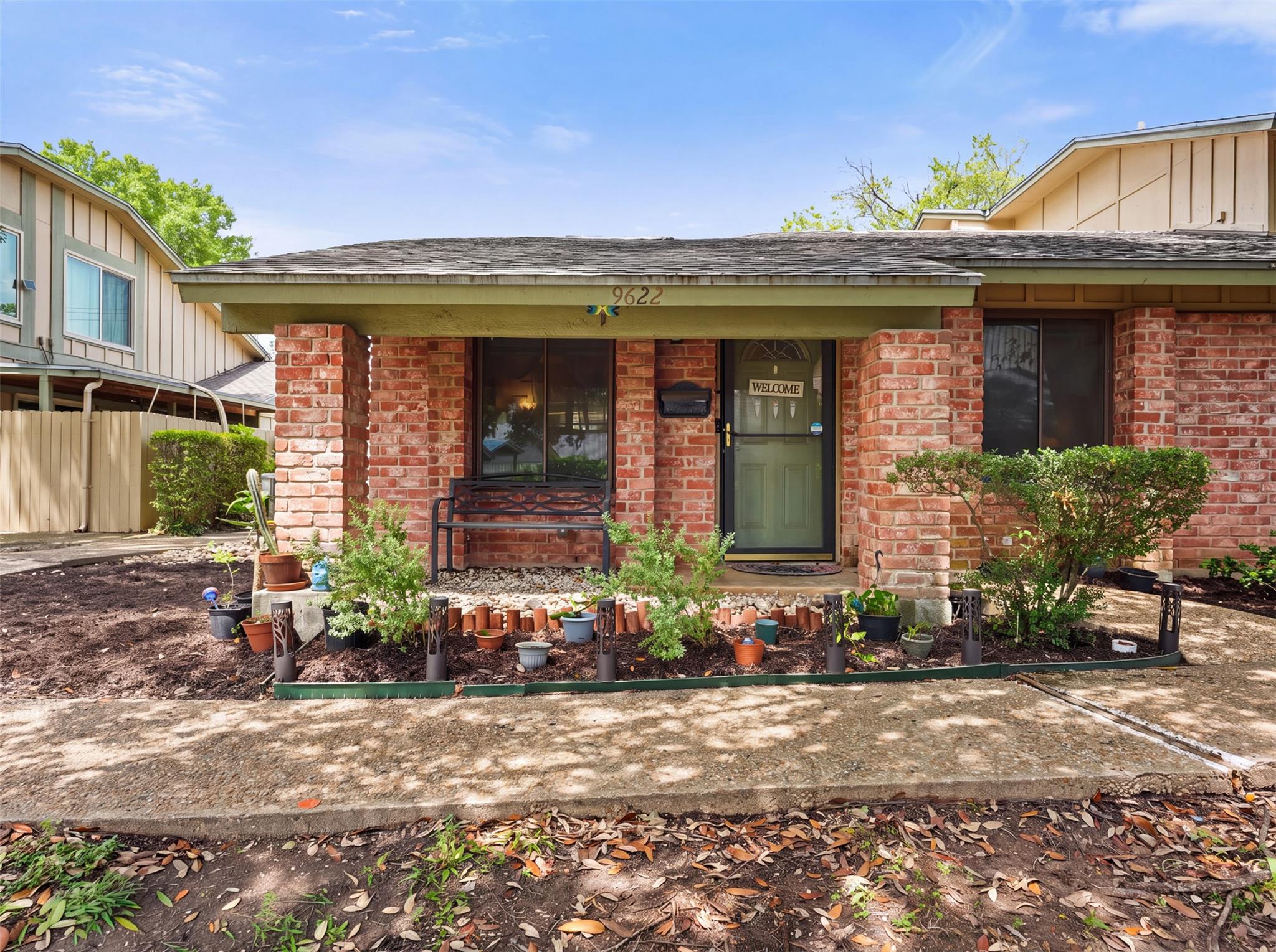 A welcoming brick facade with lush landscaping cr