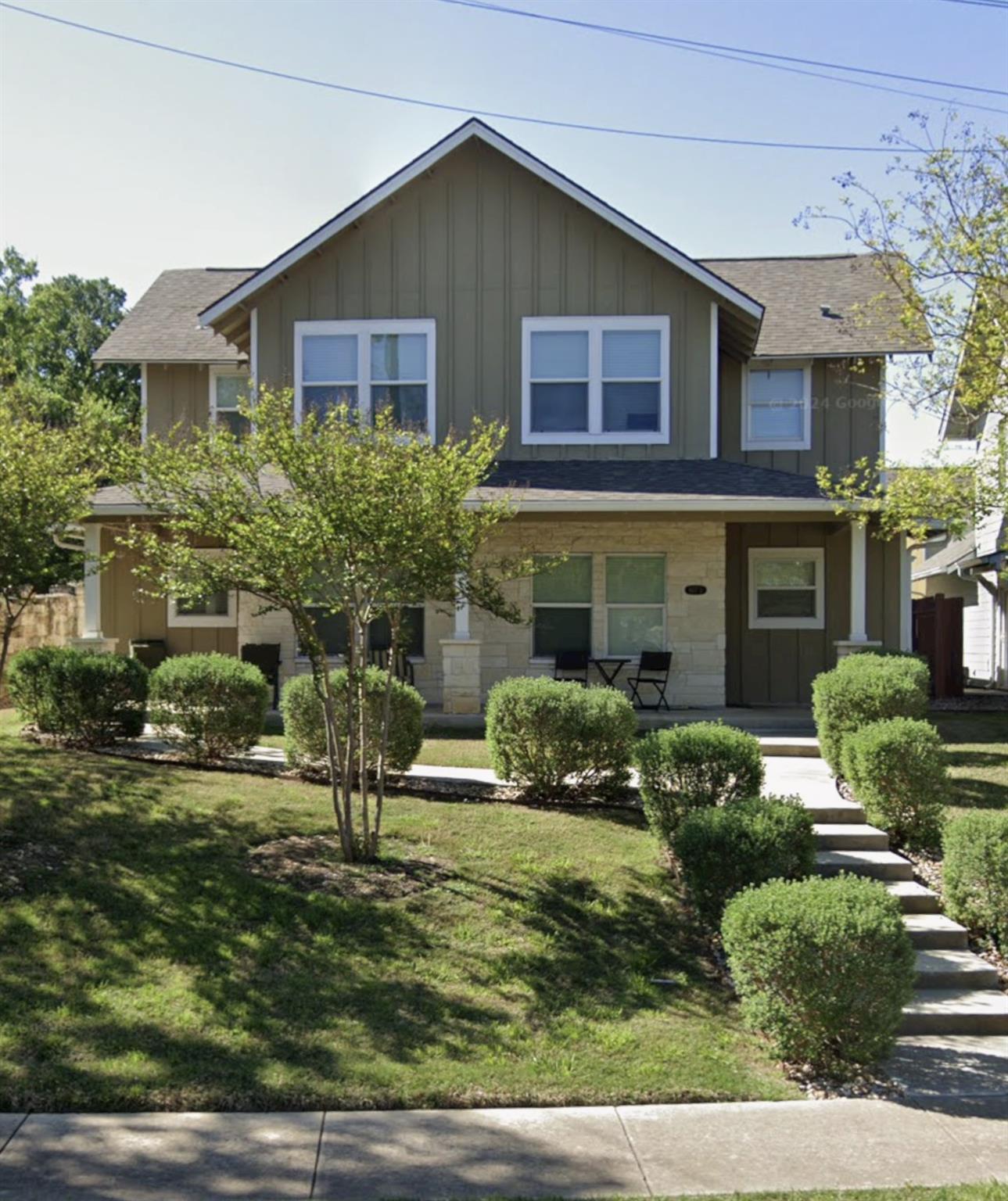 A welcoming facade with a stone-clad porch and ne