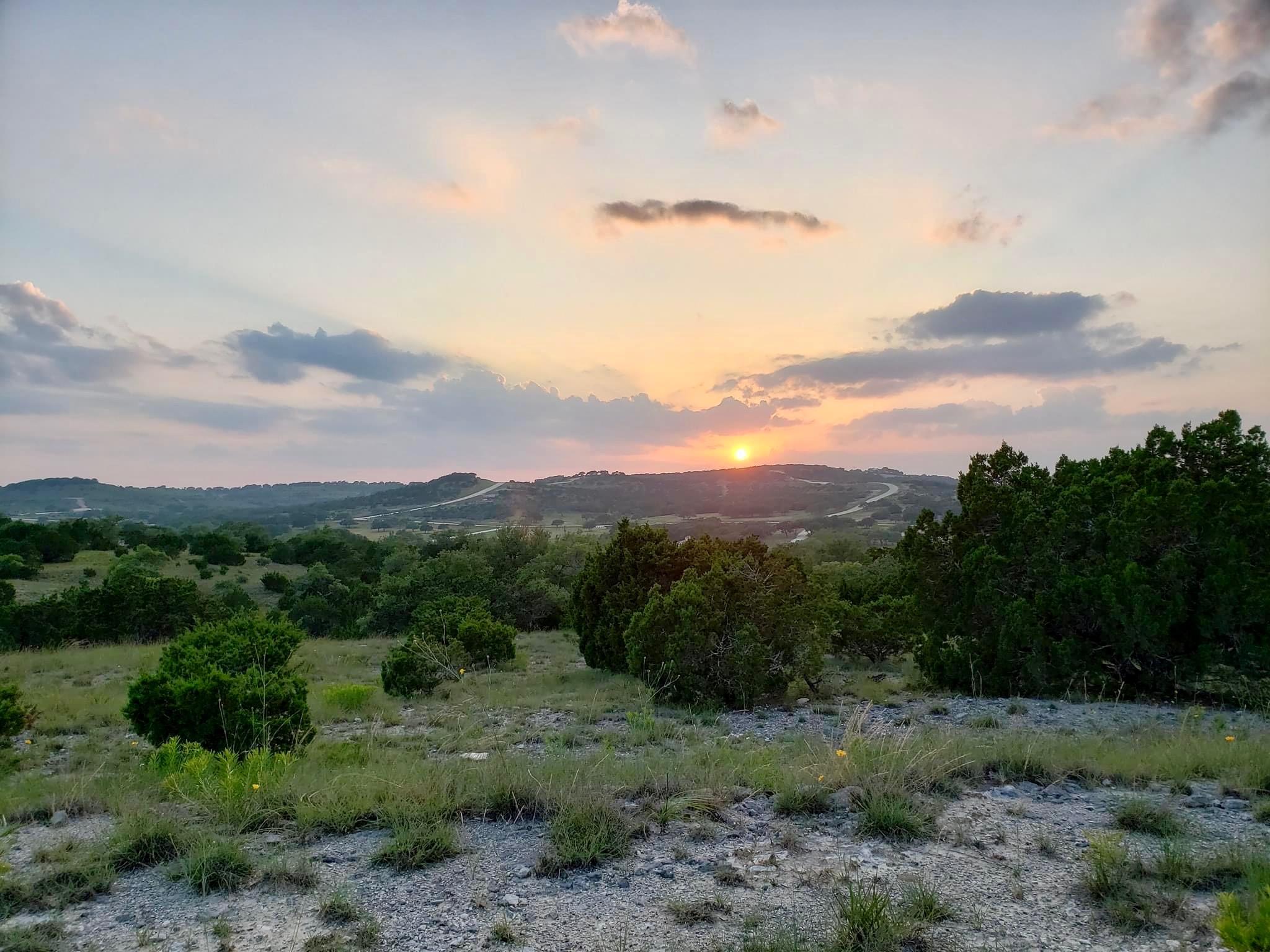 Rolling hills and mature trees frame a peaceful l