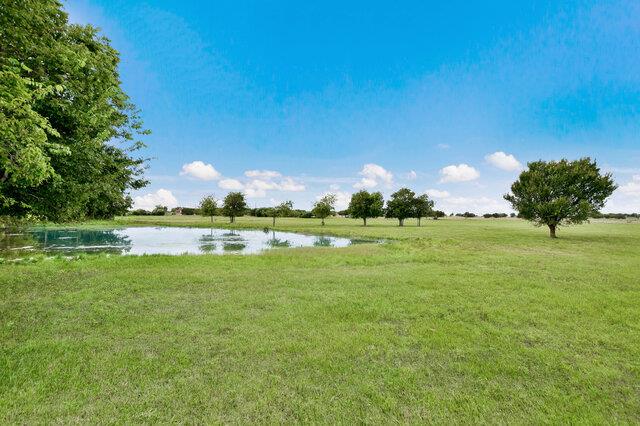 Green pastures and a serene pond offer a tranquil