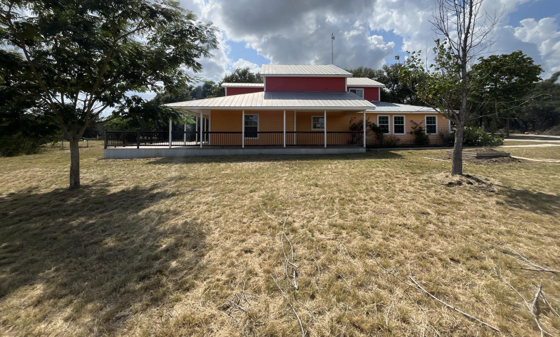 A spacious home with a wide covered porch overloo