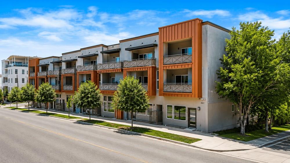 A modern multi-story complex features private bal