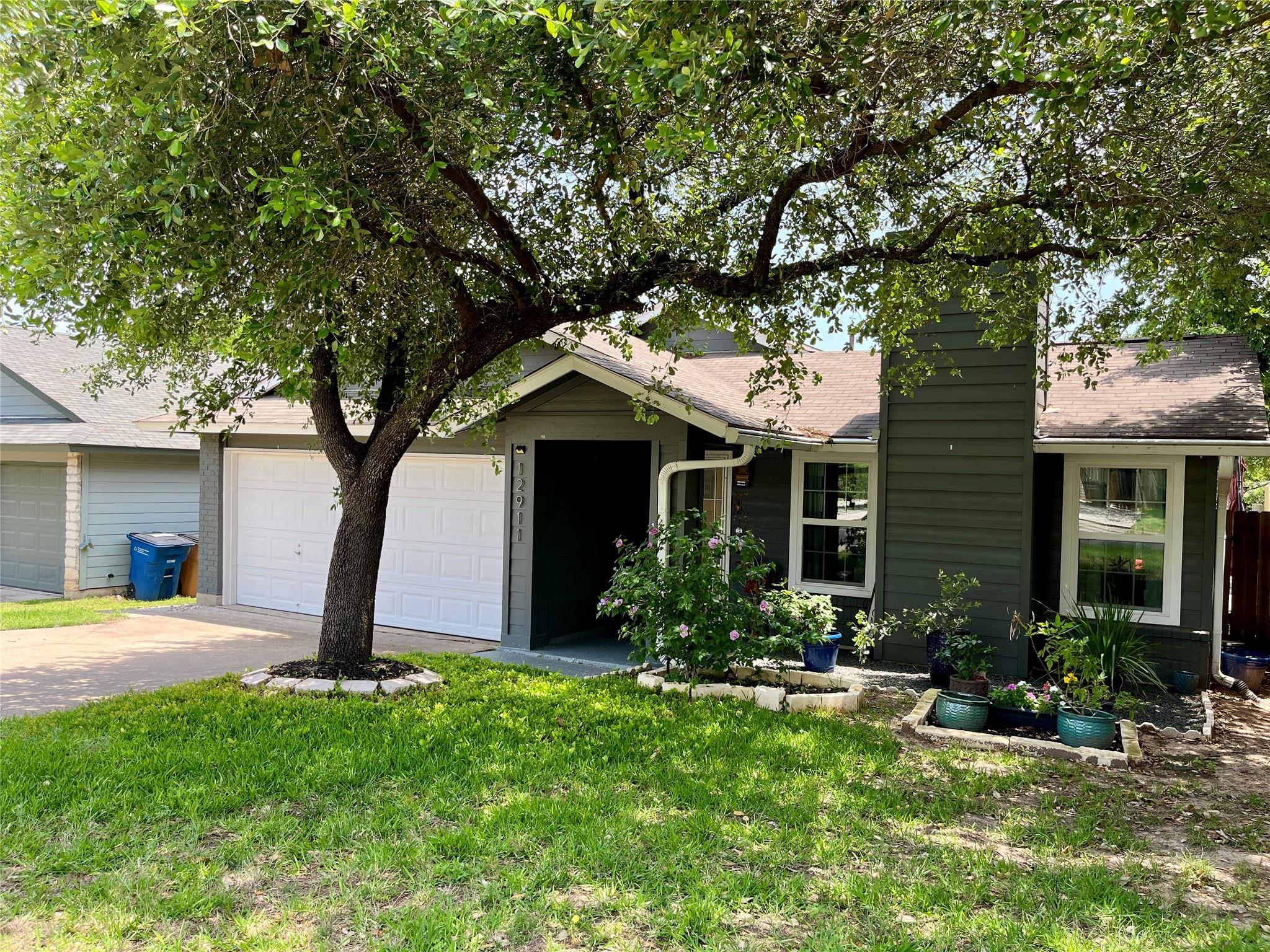 A welcoming facade with a mature shade tree, offe