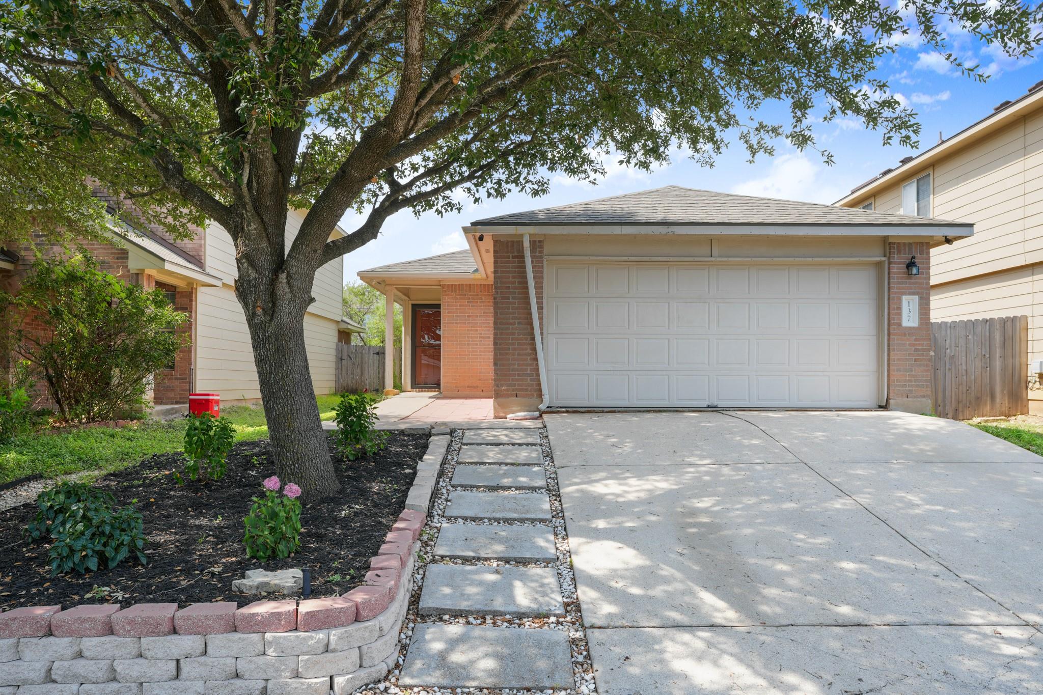 A welcoming brick exterior and a neat concrete dr
