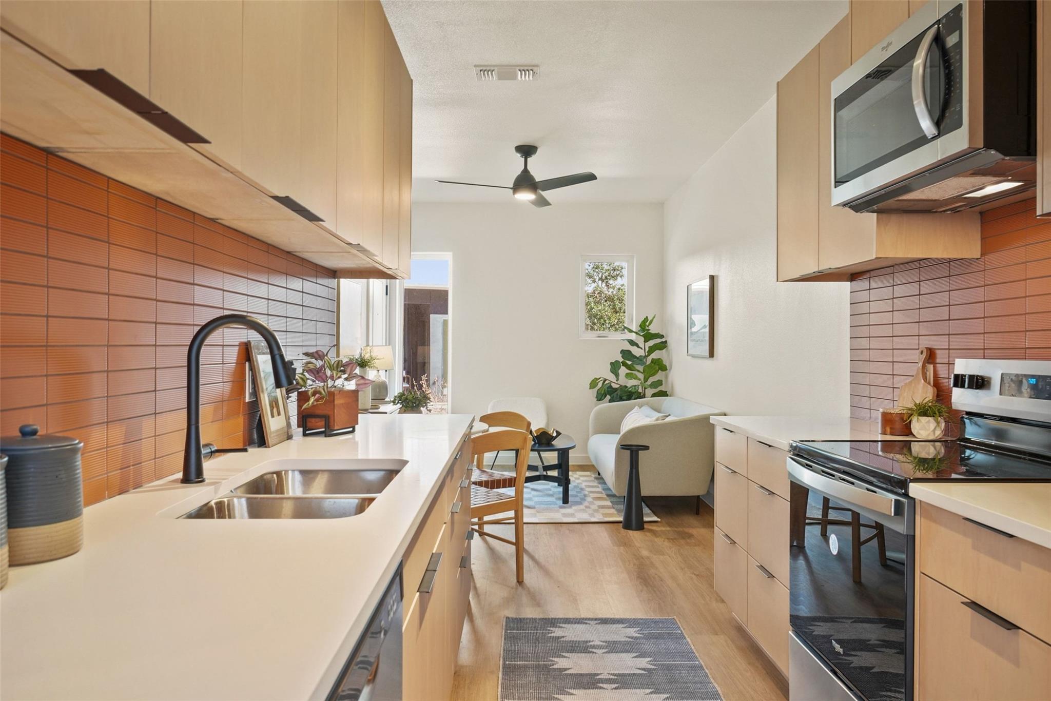 A streamlined kitchen flows into a naturally illu