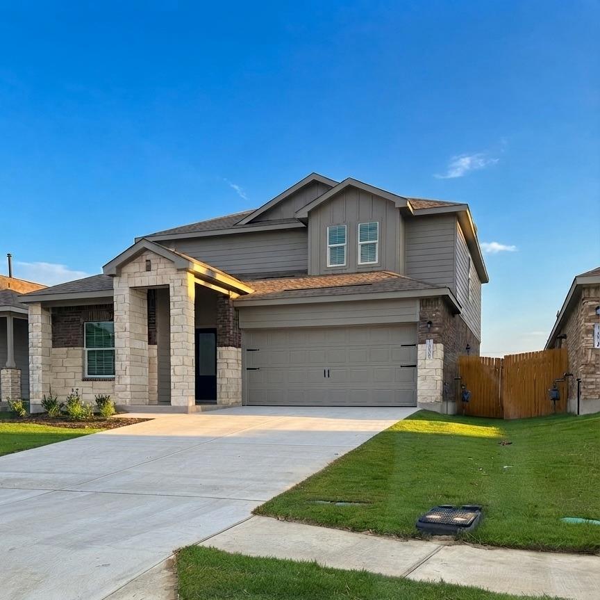 A wide concrete driveway leads to this modern two