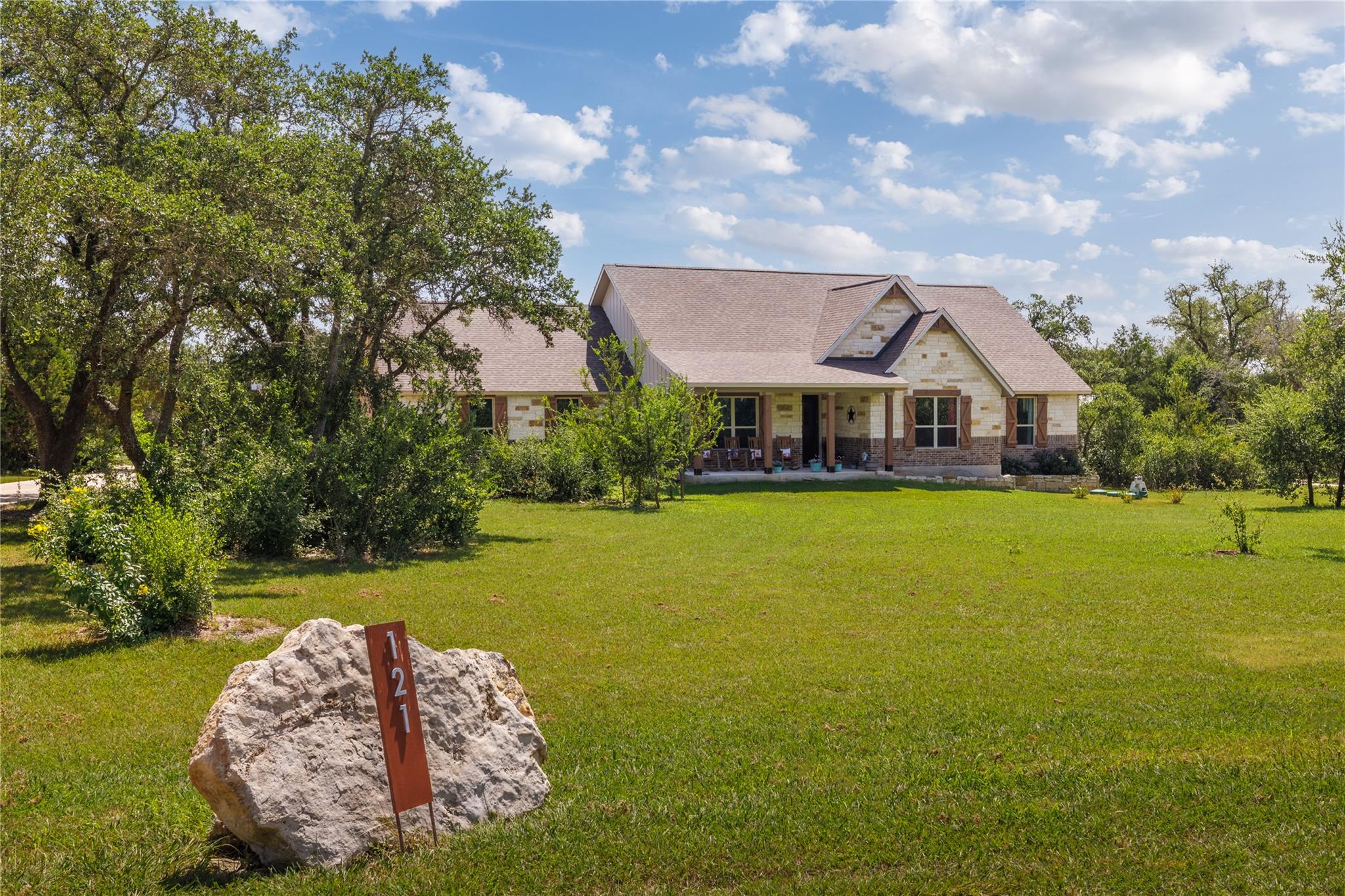 A welcoming stone and wood-accented home with a b