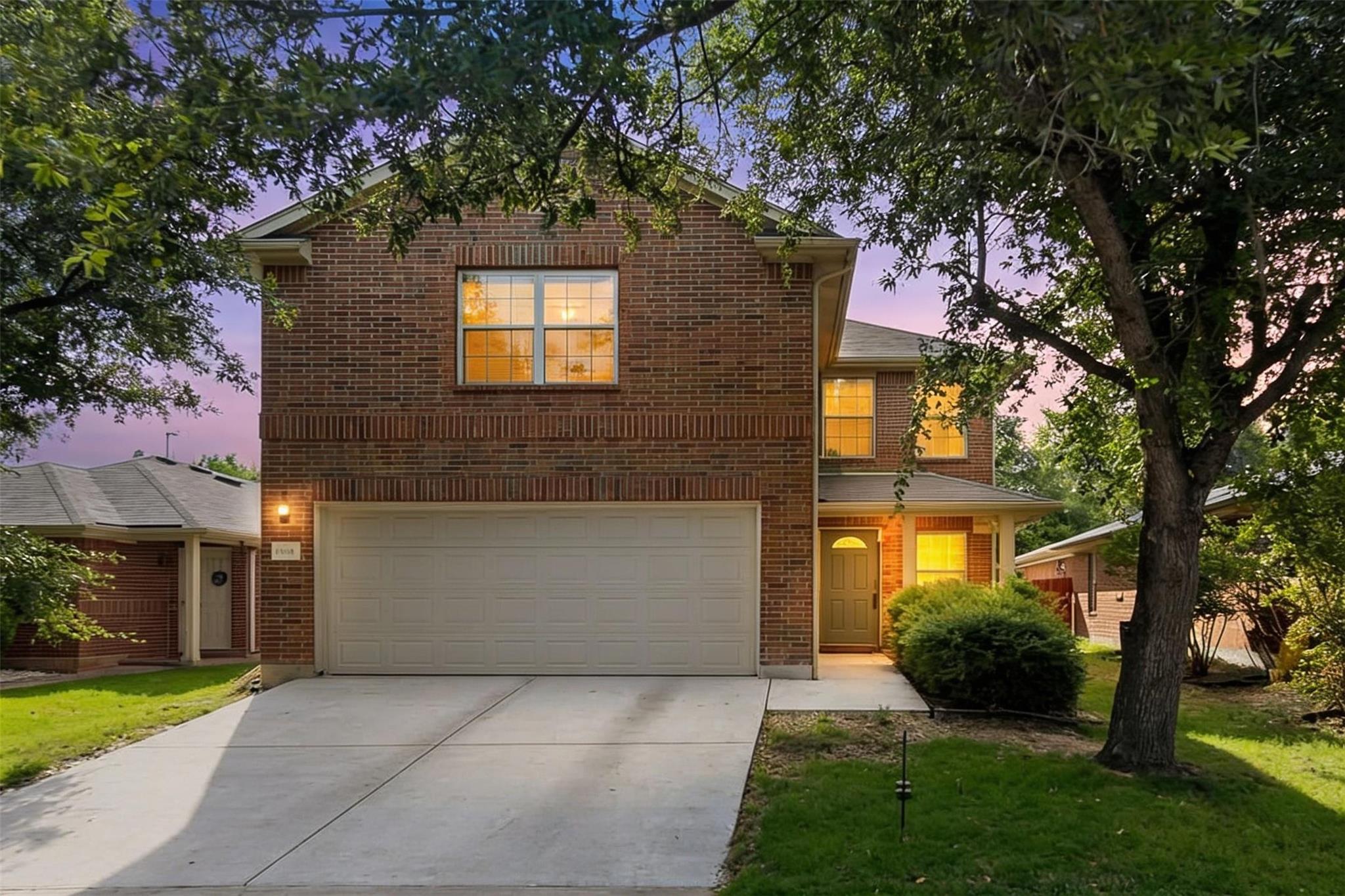 Mature trees frame a classic brick exterior compl