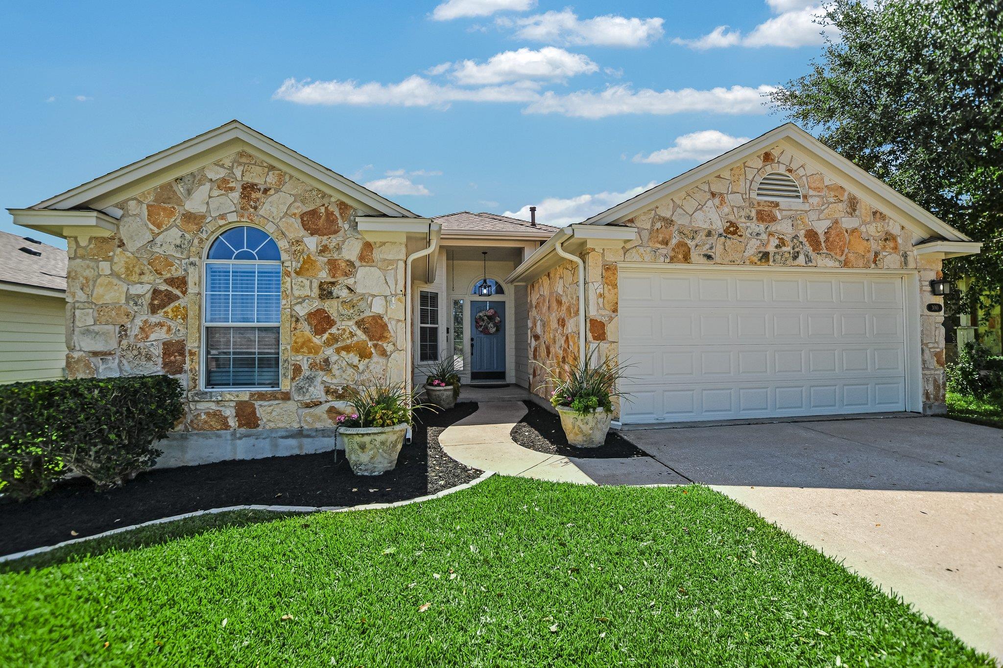 A welcoming stone facade with a manicured lawn an