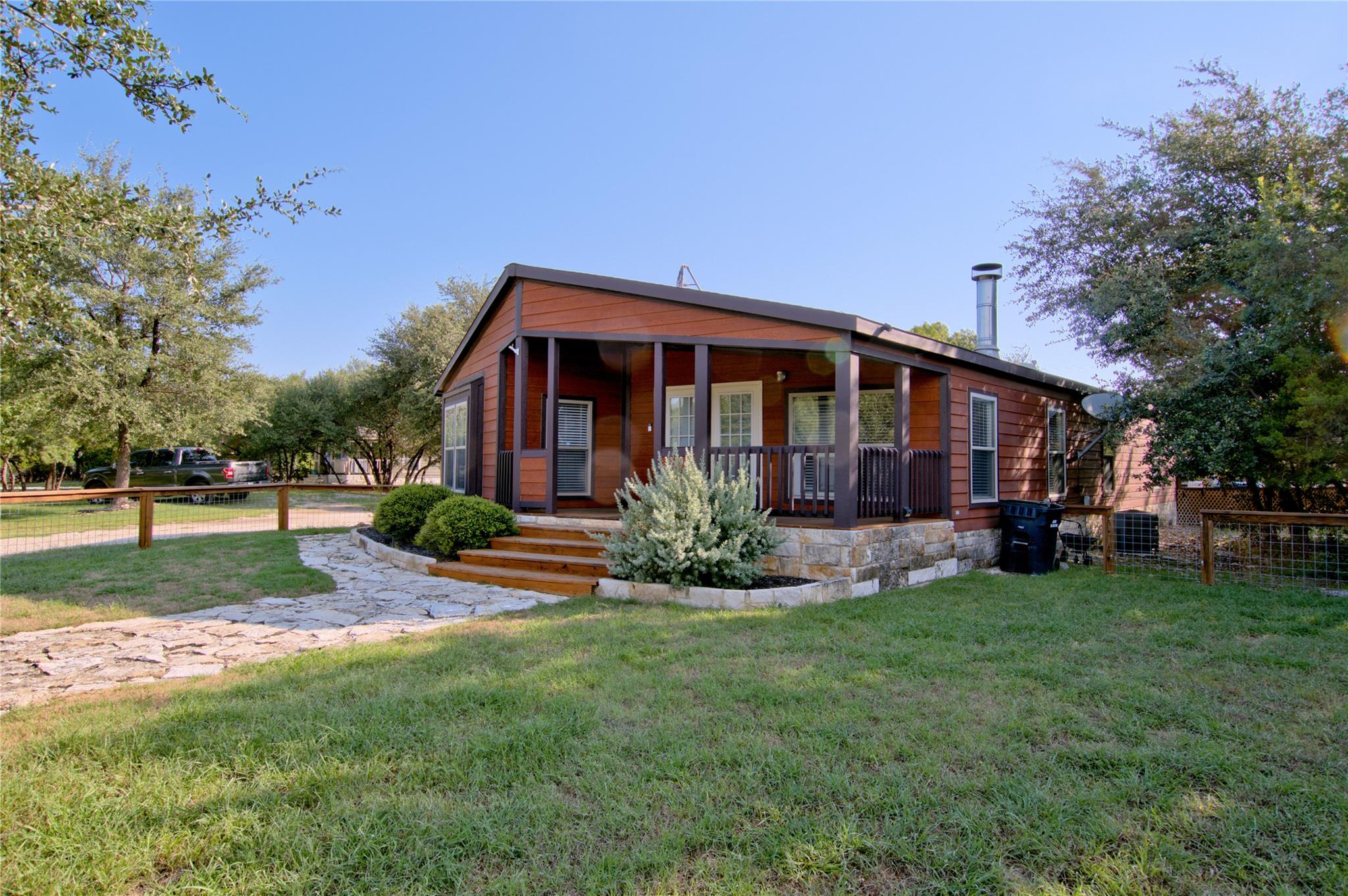 A charming brown-sided home presents a covered fr