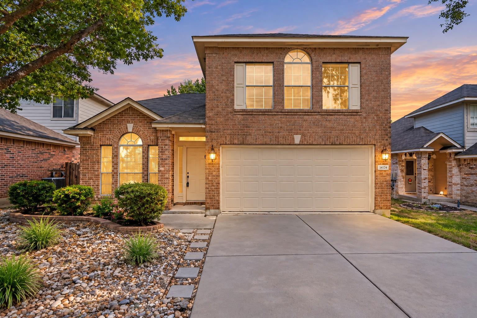 A spacious concrete driveway leads to the brick f