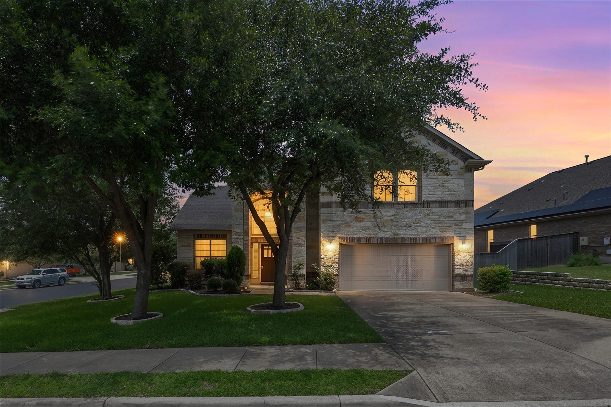 A stone-clad home illuminated by evening lights, 