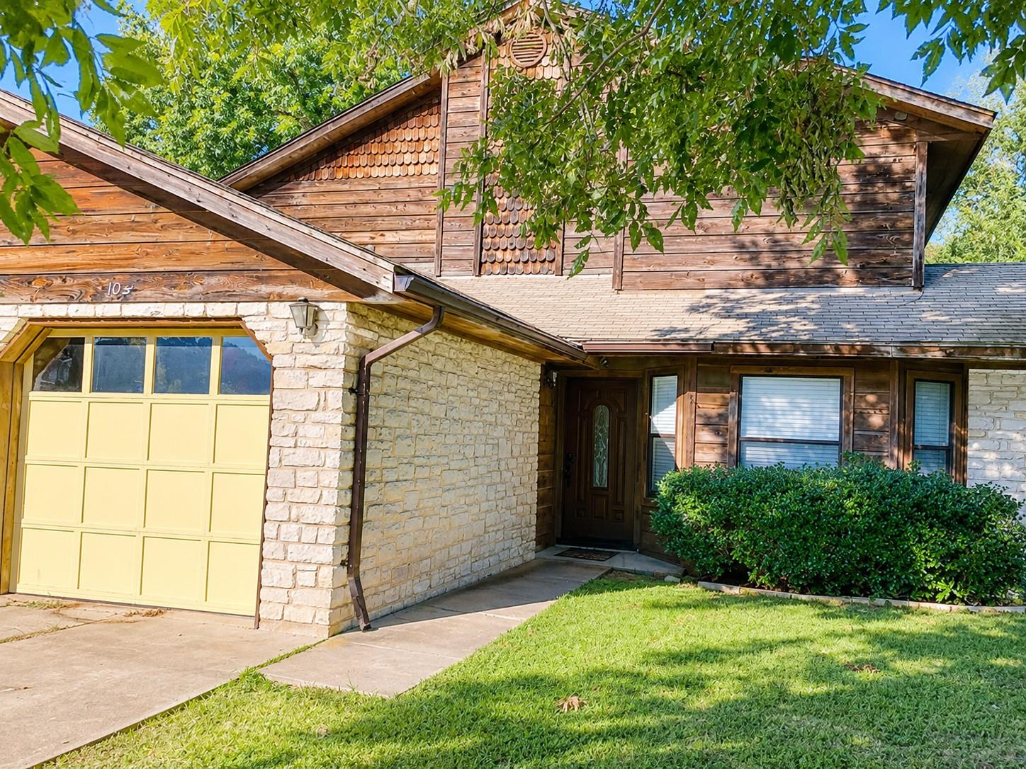 A charming home welcomes with a light-toned brick
