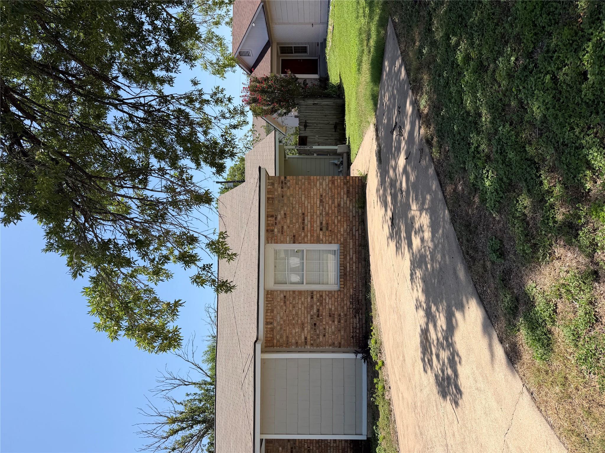 A well-maintained concrete driveway leads to this