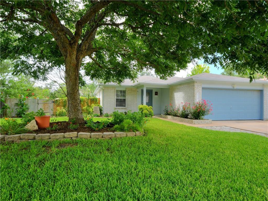 A classic brick exterior, vibrant green lawn, and