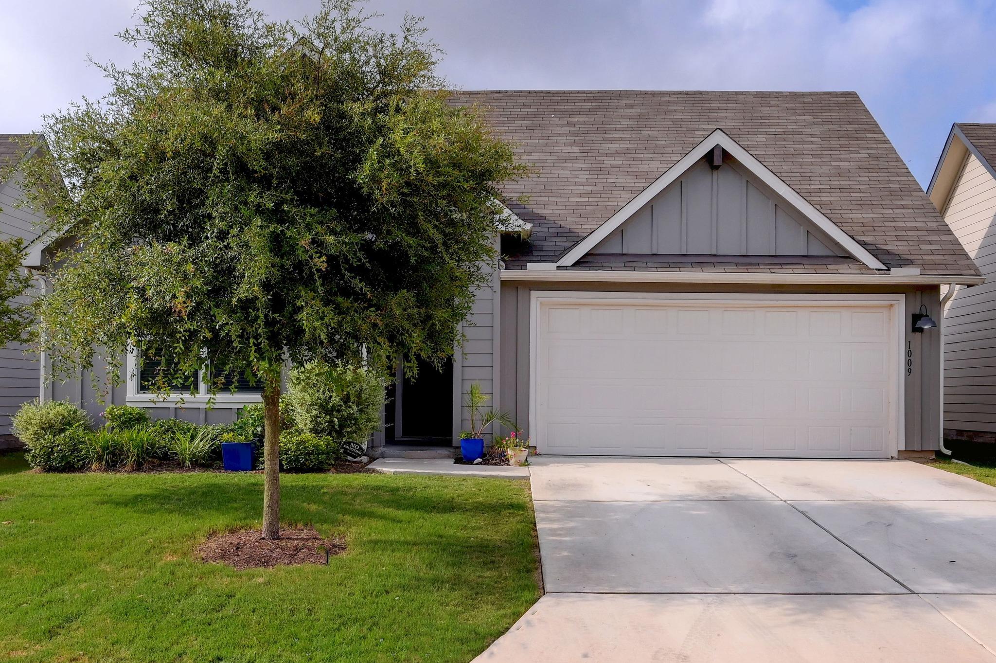 A well-maintained facade features mature landscap