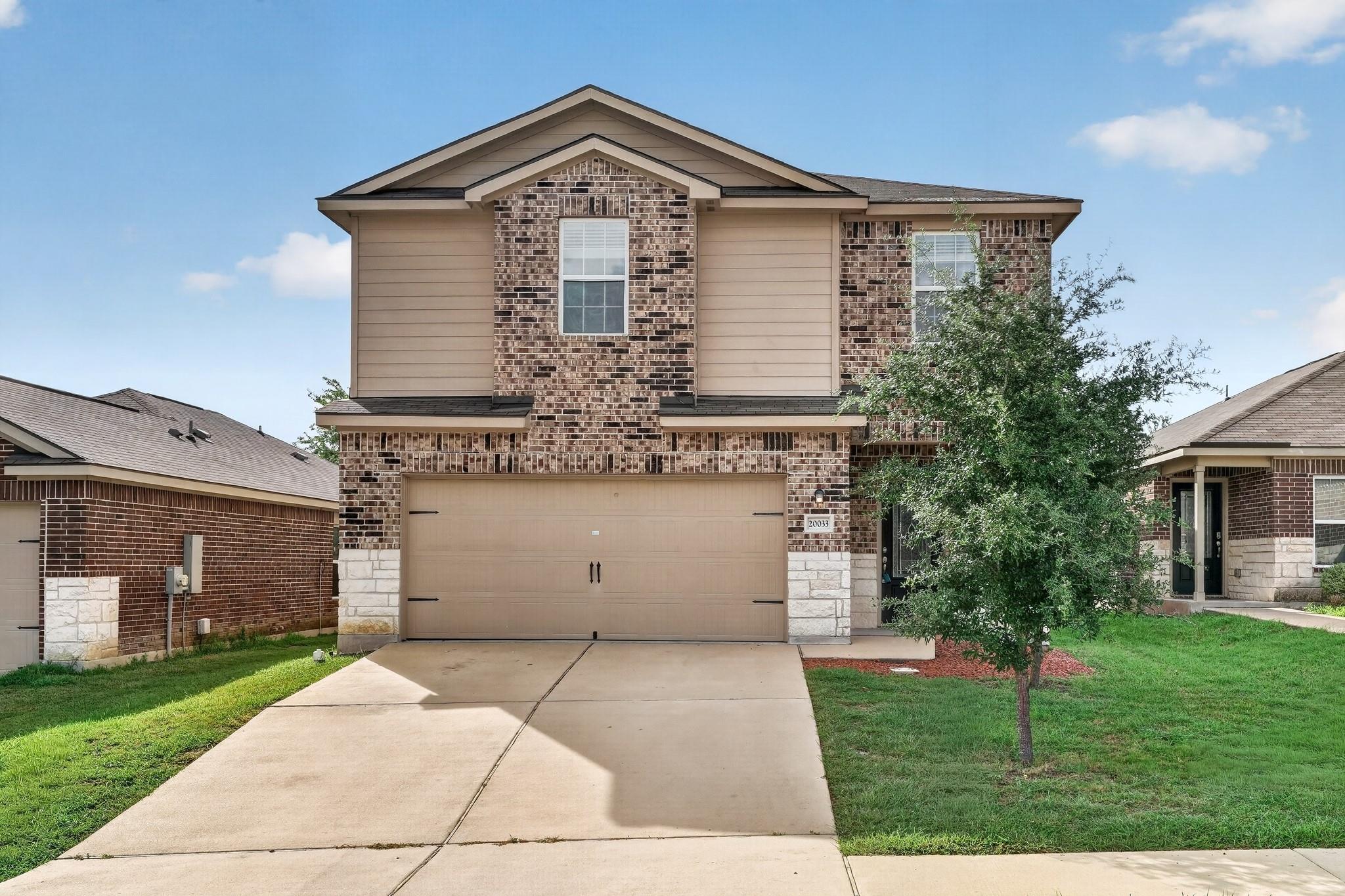 Two-story brick and siding home with an attached 