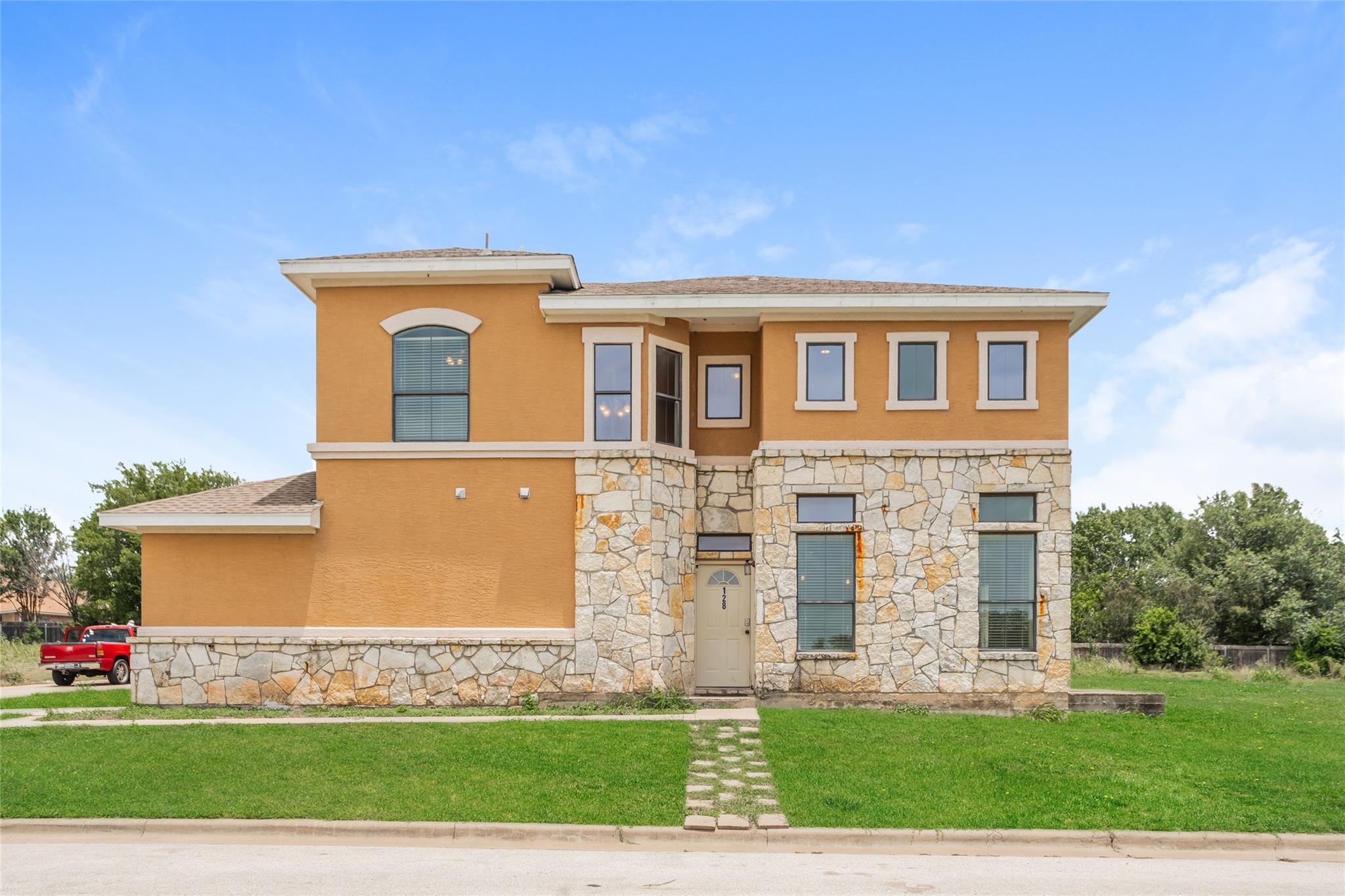 A striking facade with warm stucco and natural st