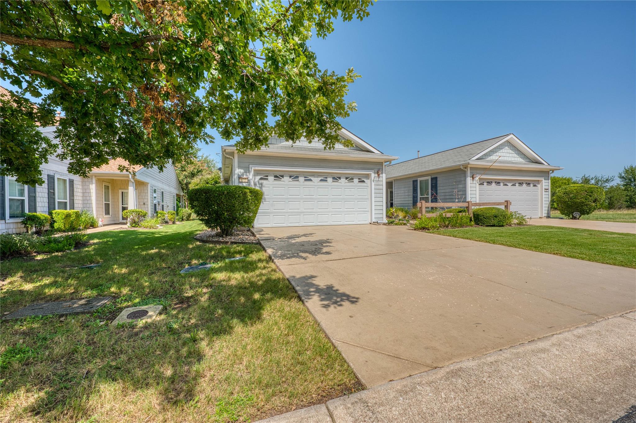 Well-maintained curb appeal with mature trees fra
