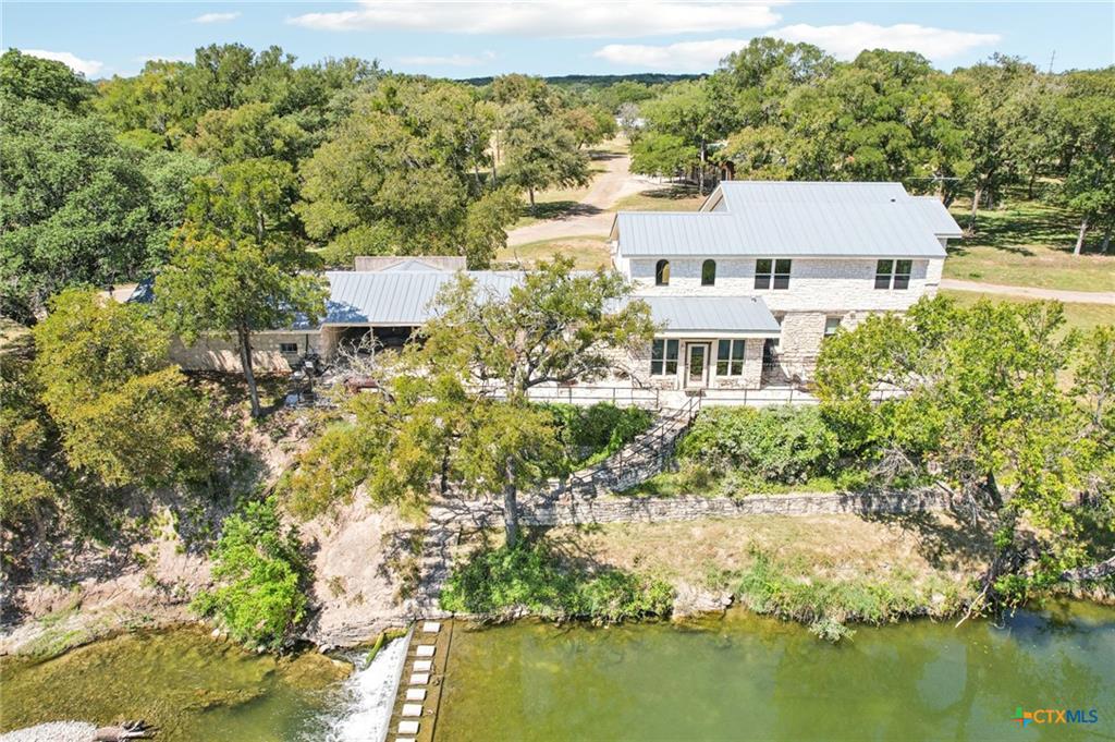 Perched above a flowing river, this stone-clad ho