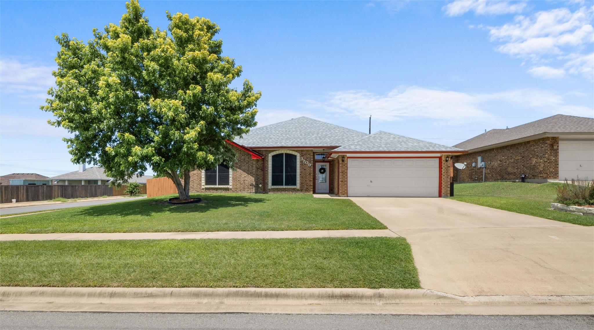 A well-maintained lawn and mature shade tree enha
