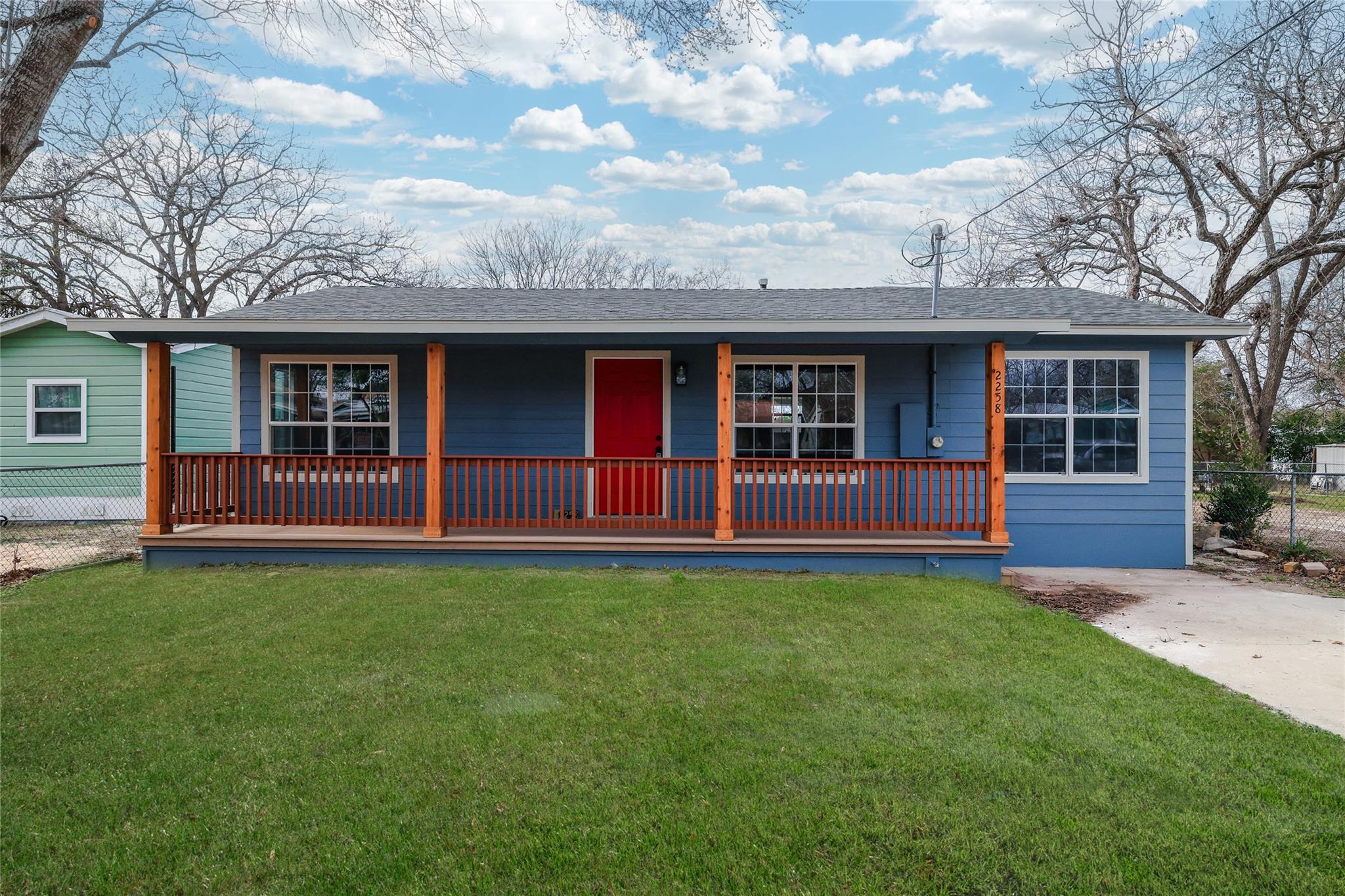 A charming blue residence with a welcoming red do