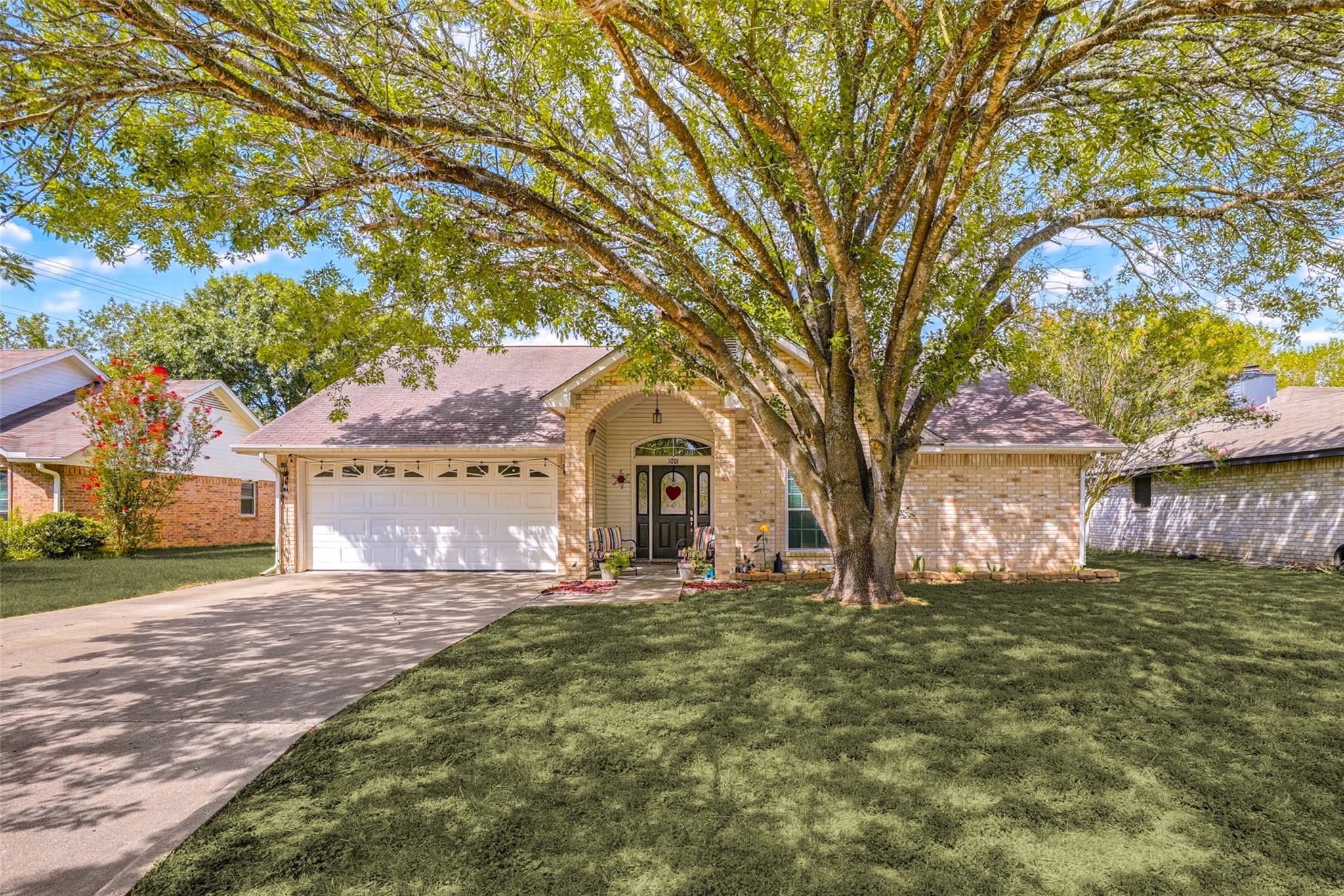 A graceful brick home welcomes with a two-car gar