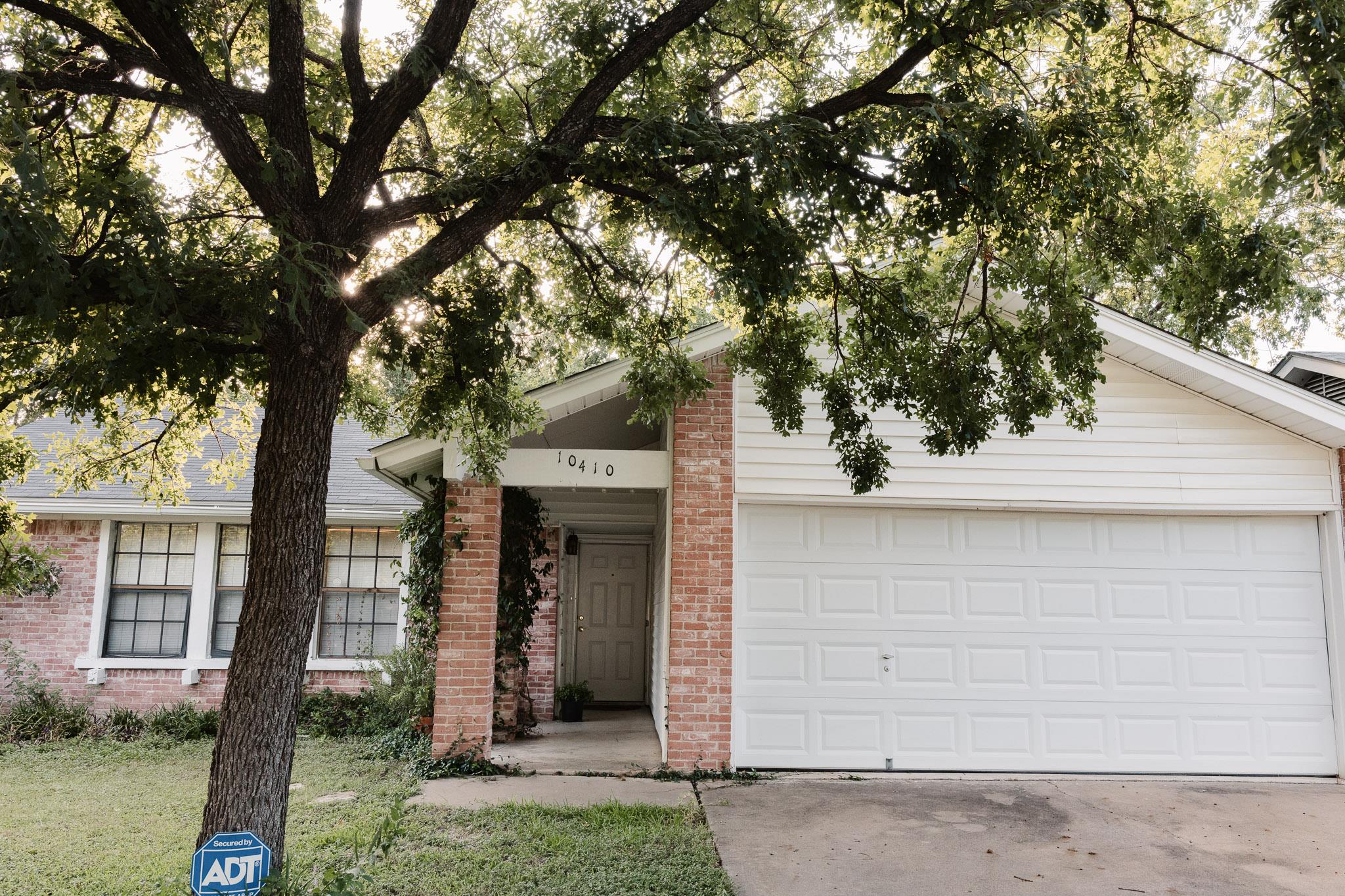 A classic brick and siding home presents a welcom