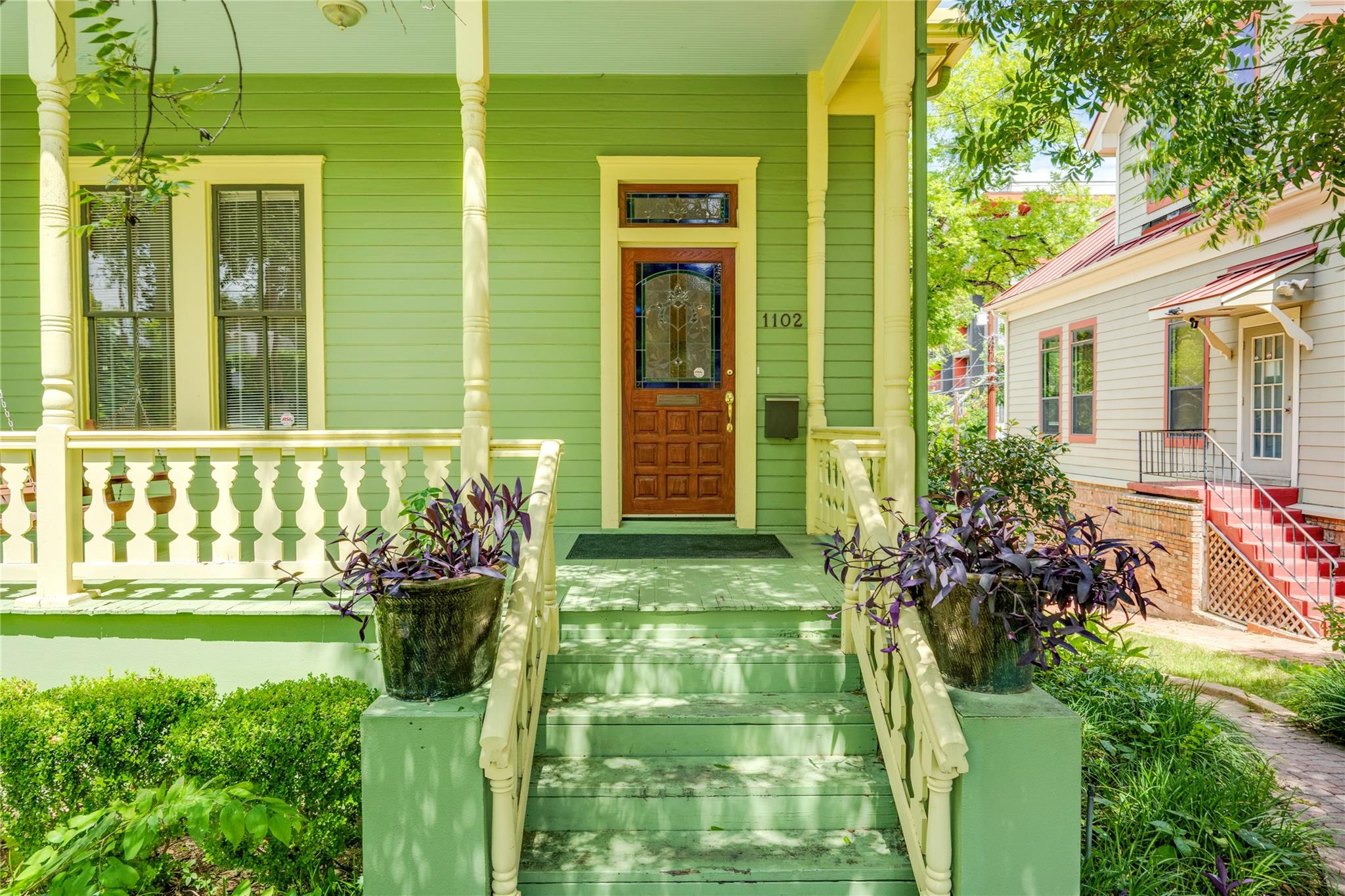 A welcoming front porch features charming baluste