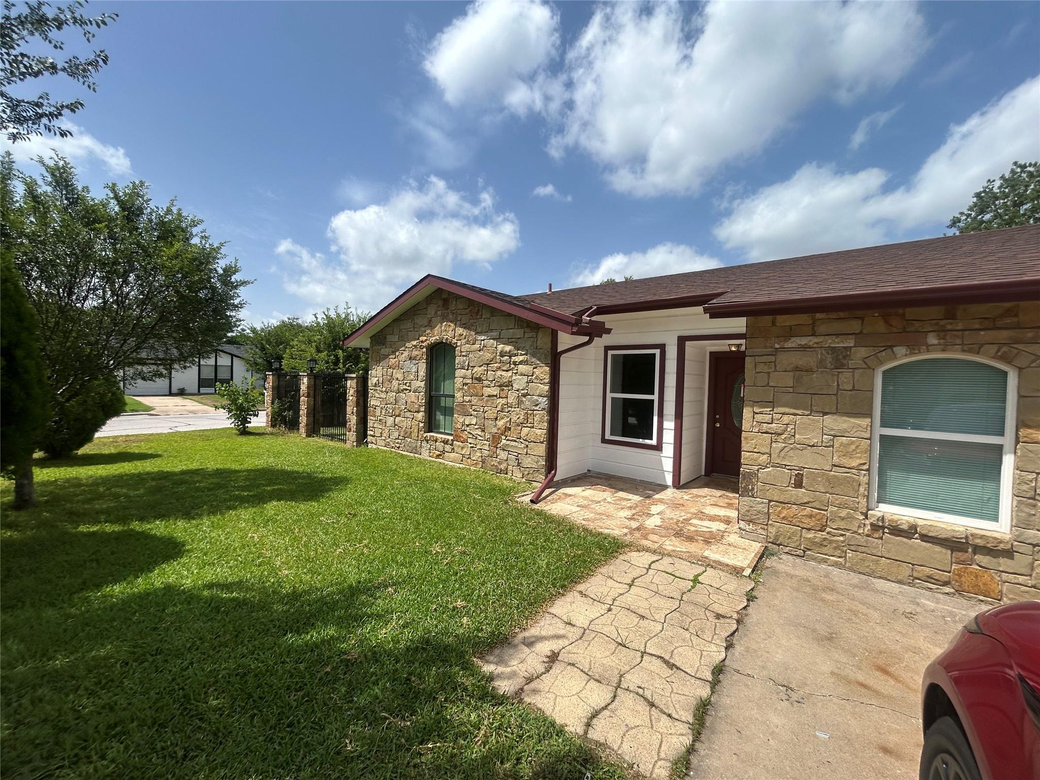 Natural stone masonry and a paved walkway define 