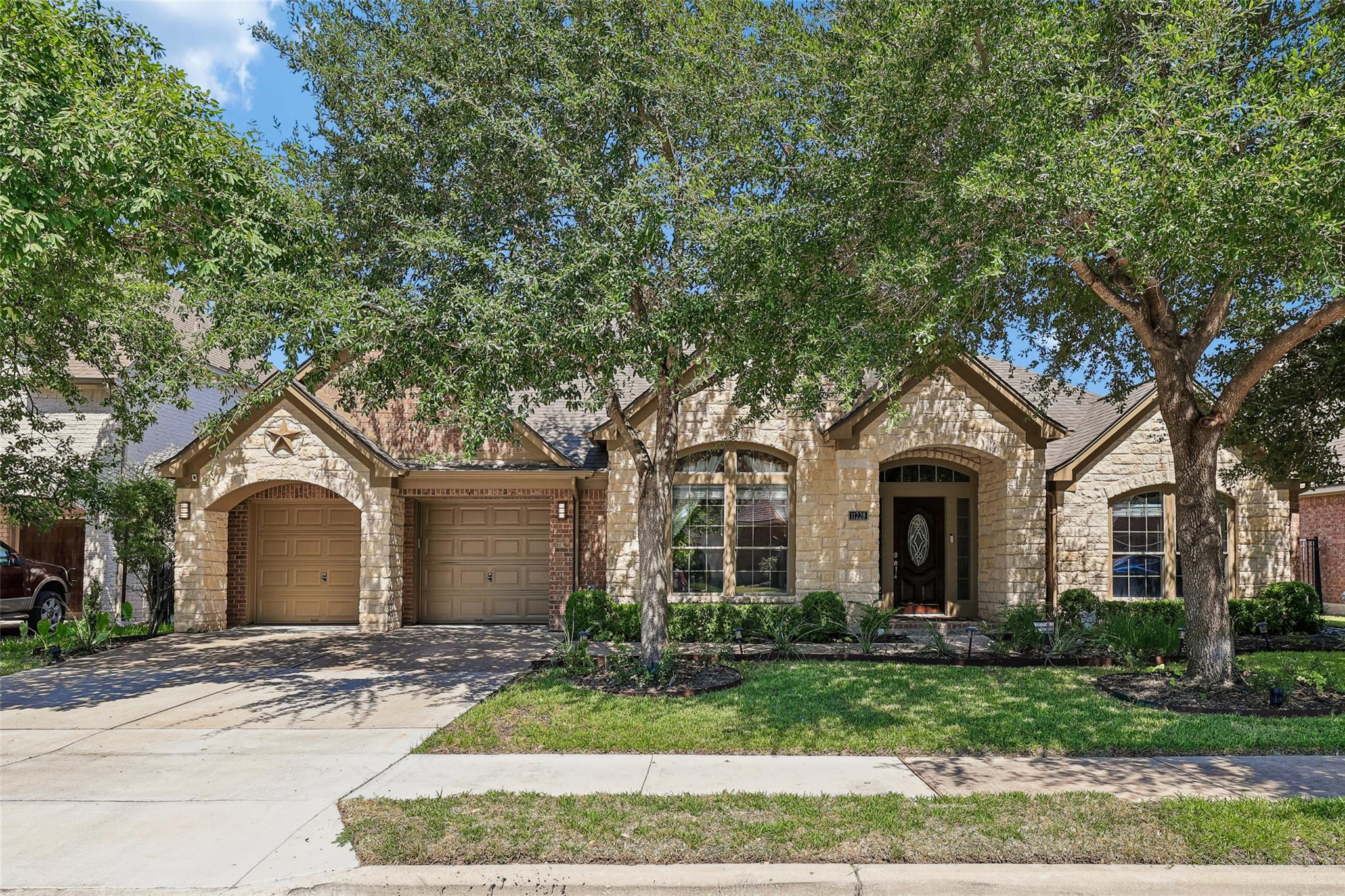 A welcoming stone and brick facade is framed by m