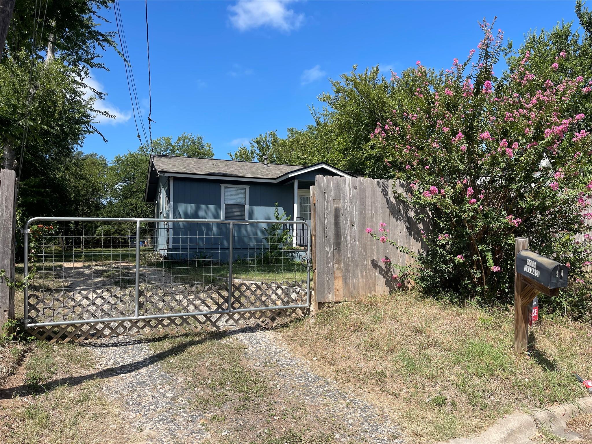 A welcoming front yard with a security gate, matu