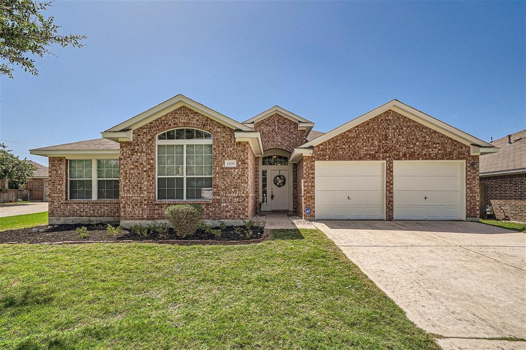 A classic brick facade and a tidy front lawn offe