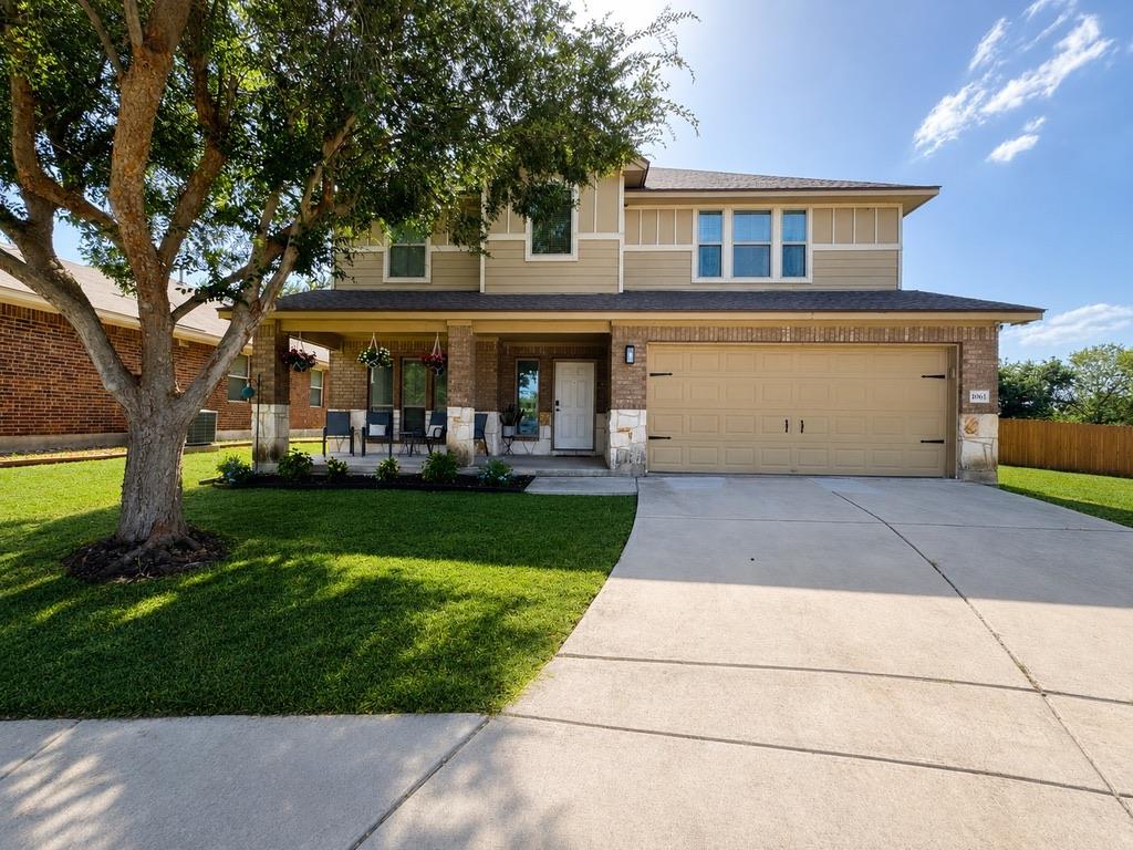 Mature trees shade the concrete driveway and welc