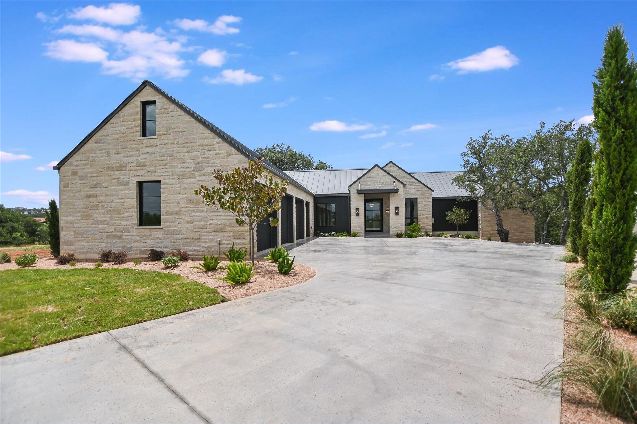 A sprawling driveway leads to this modern home fe