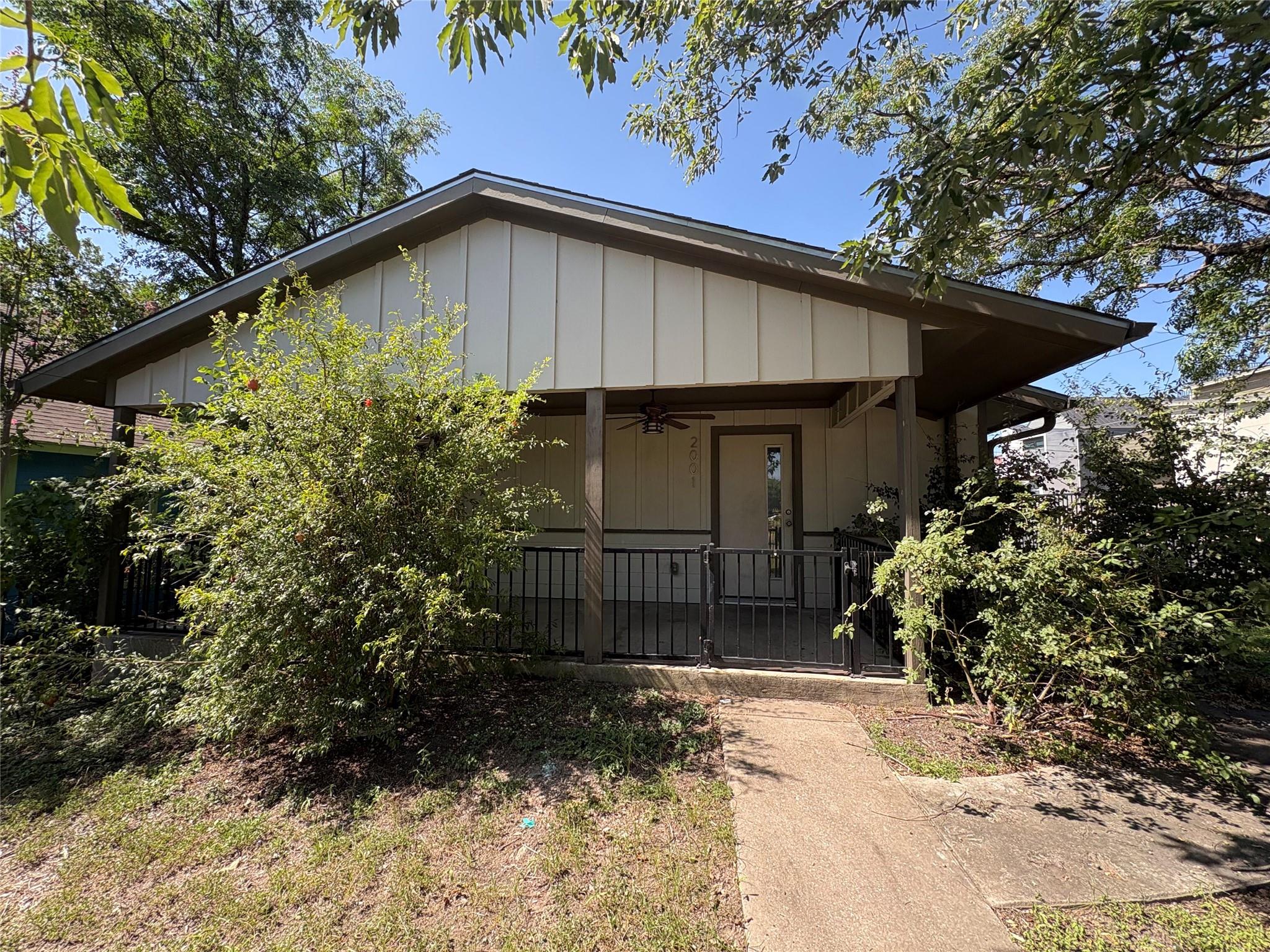 A welcoming front porch, shaded by mature trees, 