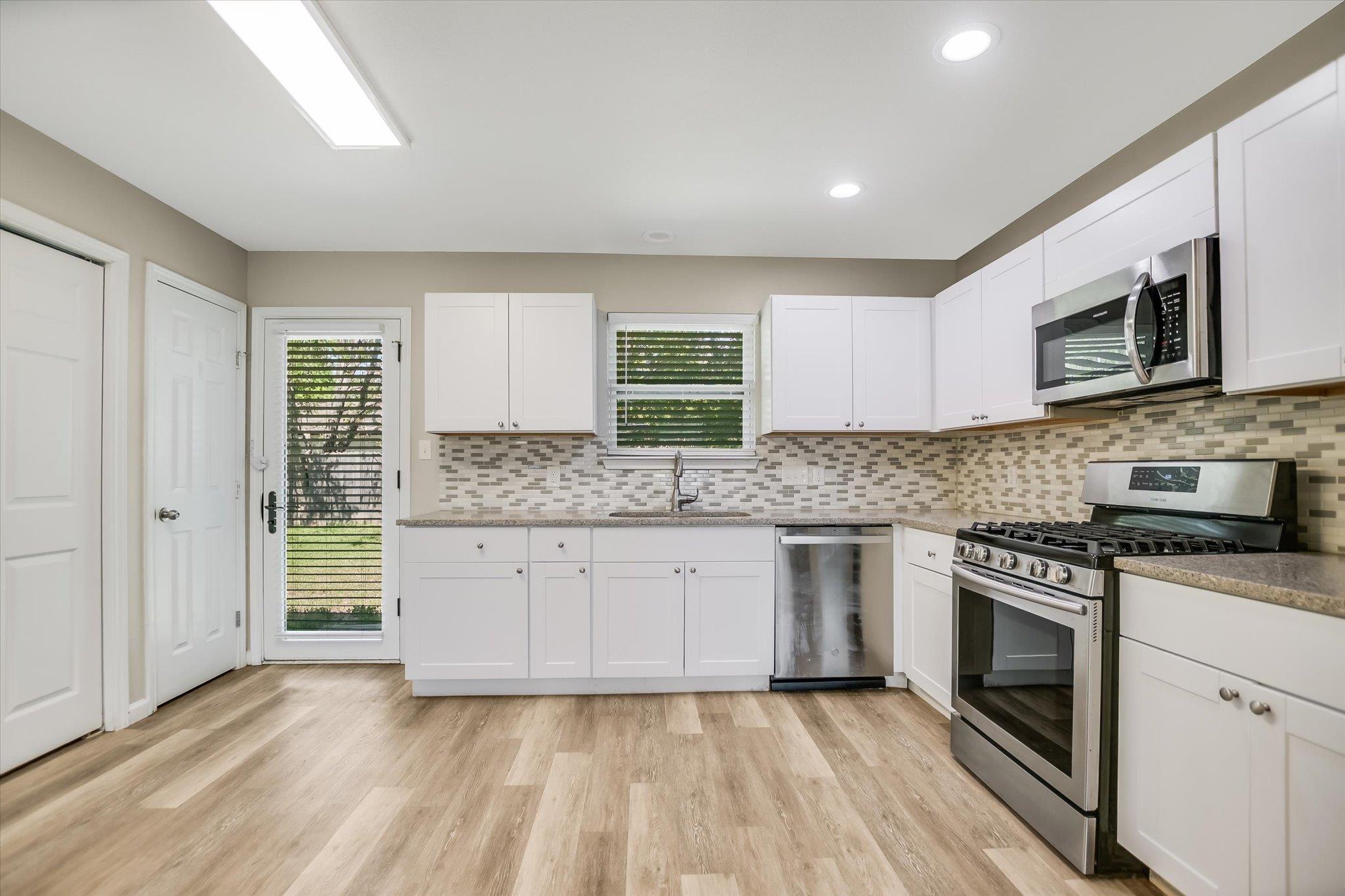 A well-appointed kitchen features ample white cab