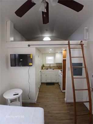 A compact living space features a lofted area wit