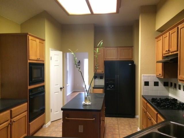 Ample wooden cabinetry and a central prep island 